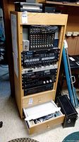 Front view of oak rack with mixer, processors, amplifiers and drawers with cables