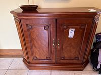 Frontal view of the wooden hall table with two cabinet doors and decorative carved accents.