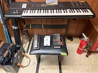 Front view of Korg M1 workstation on stand with pedal board and stool