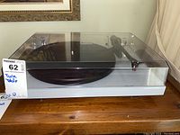 Front view with dust cover closed showing grey plinth and black platter