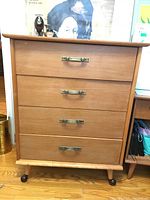 Full front view of the dresser showing four drawers and caster wheels.