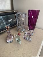Photo of six hand blown glass items: two vases and four figurines including a ram, bird, dolphin, and fairy.