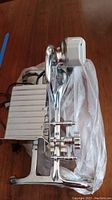 Photo of Rival Mfg Co. electric meat slicer showing chrome and metallic body, circular blade, and adjustment knobs.