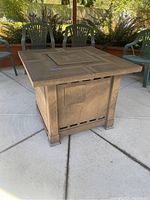 Front and top view showing the detailed patterned metal top and overall square shape of the fire pit