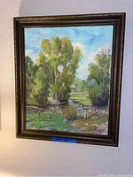 Full frontal view of one framed painting showing rural landscape scene