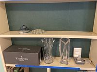 Shelf showing Waterford box, two clear crystal vases, triangular bowl, and small boxed crystal figurine.