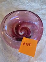 Top-down angle of purple glass art bowl showing spiral swirl inside.