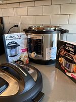 Instant Pot Ultra 6 Quart pressure cooker with lid and two recipe booklets displayed on a kitchen countertop.