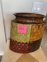 Front view of large ceramic vase showing multicolor patchwork with textured floral and geometric designs.