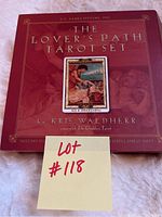 Front cover of the tarot set box showing title and creator, red tones with classic artwork display.