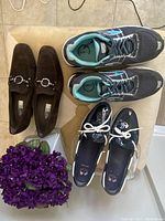 Overview showing three pairs of women's shoes: two loafers and one pair of athletic sneakers.