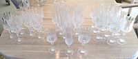 Photo showing full 35 pieces of cut crystal stemware arranged grouped by type on a table.