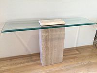 Side angle showing the full contemporary entry table with marble base and clear beveled glass top.