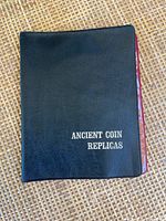 Front cover of the black folder labeled 'ANCIENT COIN REPLICAS'