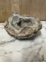 Large geode showing the rough outer surface and the hollow interior filled with crystals.