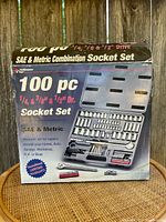 Closed box showing Performance Tool 100 piece SAE & Metric Combination Socket Set with 1/4, 3/8, and 1/2 inch drives