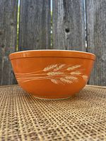 Front view of the Pyrex orange Autumn Wheat mixing bowl showing white wheat stalks design.