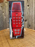 Front view of vintage Merlin game box showing the red handheld electronic game with keypad and buttons.