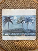 Back cover of the book with an illustration of palm trees and a moonlit night sky, showing wear and stains on the cover.