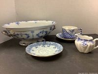 Photo showing full set including large casserole dish, cup, saucer, and creamer