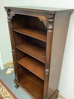 Full side view of the vintage wooden bookcase showing overall shape and shelves