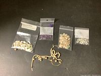 Full view of lot with five visible bags and a vintage faux pearl necklace.