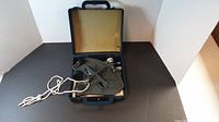 Ebbco sextant inside its black carrying case with yellow foam lining, rope attached to the sextant visible.