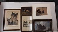 Overview of five framed vintage art pieces on a white surface including architectural prints, pencil sketch, and 3D dog artwork.