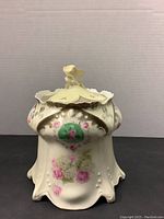 Front view of vintage RS Prussia biscuit jar with floral design and scalloped edge lid.