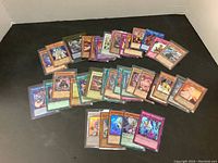 Photo showing a portion of the approximate 40 Yugi-oh trading cards spread out, displaying various card designs and types.