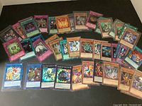 Wide layout of approx 40 Yu-Gi-Oh trading cards, various types and editions with some in sleeves.