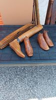 Multiple wooden boot molds in different sizes and shapes displayed on a surface, showing variety within the set.