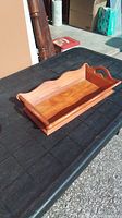 Full side view of the vintage wooden fruit tray showing the carved raised edges and handle detail.