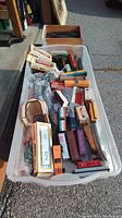 Plastic container with multiple model train cars including boxed Bachmann HO scale trains marked CN, loose train cars in orange and red, and some accessories.