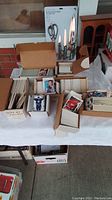 Photo showing large quantity of vintage card boxes and loose cards laid out on table, in cardboard storage boxes.