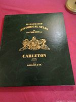 Front cover of the atlas showing title and publisher information in gold on dark green hardcover.