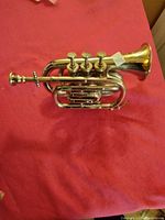 Side view of the vintage mini trumpet showing the valves and bell.