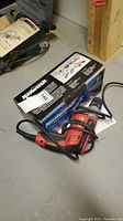 Mastercraft 4 1/2 inch angle grinder with cord and box on concrete floor.