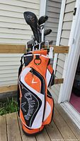 Callaway golf bag filled with golf clubs including drivers and wedges, seen from front angle.