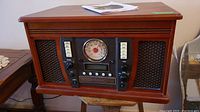 Front view of the music center showing radio dial, controls, and speaker grills.