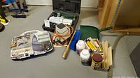Full lot overview with rotary tool kit, drill bit sharpener, woodworking supplies including glue, wood strips, brush, and dustpan.