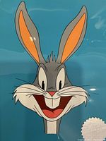 Close-up of Bugs Bunny headshot cel on blue background with silver foil seal reading 'Bob Clampett Animation Art Hand Painted #16/250'.
