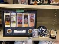 Full view of framed ticket collage, helmet, and card.