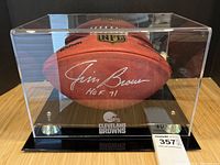 Signed football inside acrylic display case on tabletop