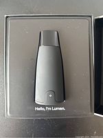 Black handheld Lumen device in original packaging with text 'Hello, I'm Lumen.'