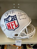Front-right view of white helmet showing NFL shield and three signatures