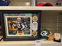 Overview of lot including framed Aaron Rodgers plaque, signed Aaron Jones mini helmet, Super Bowl I coin