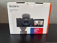 Front of sealed Sony ZV-1 digital camera box showing camera and flip-out screen image