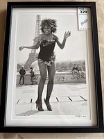 Framed black and white photograph of Tina Turner in front of the Eiffel Tower, full view