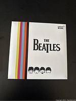 White outer sleeve with multicolor stripes, The Beatles logo and Montblanc branding